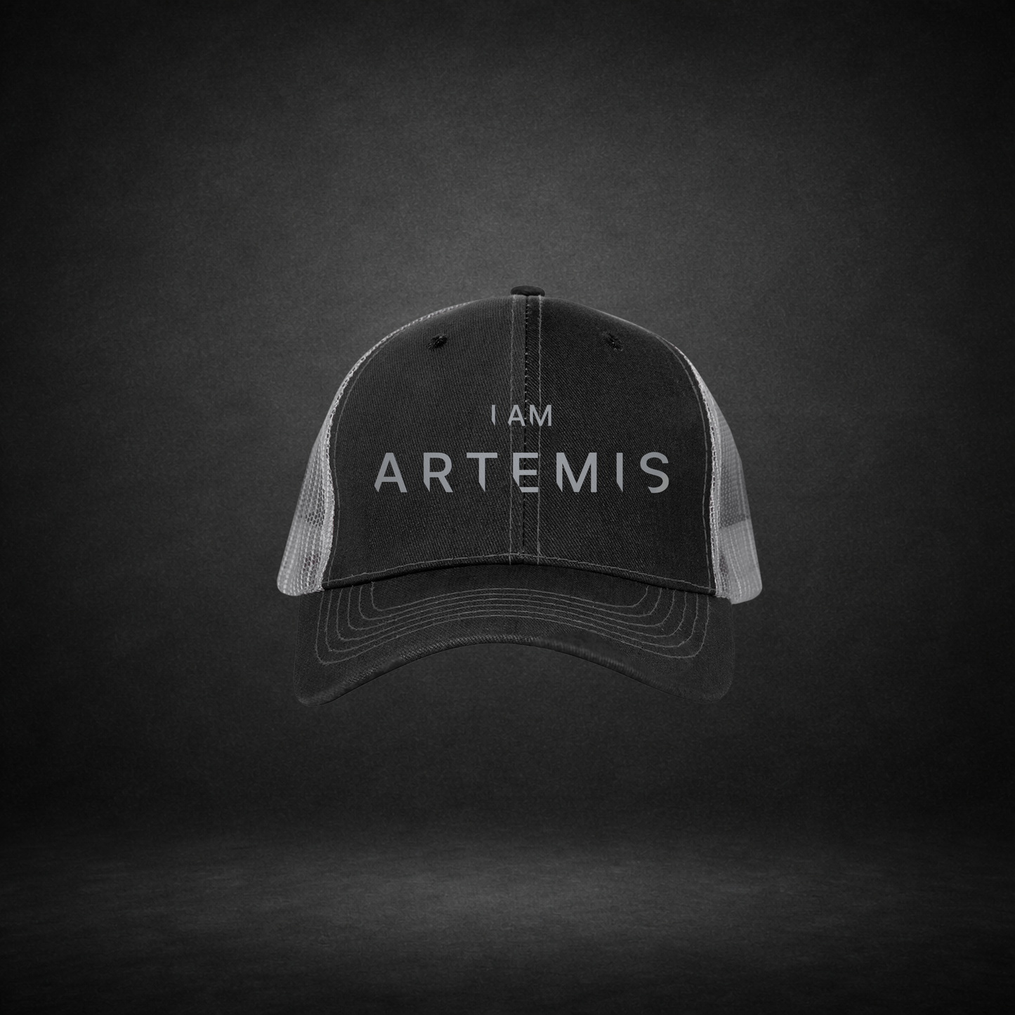 Black cap with 'I AM ARTEMIS' text on a dark background